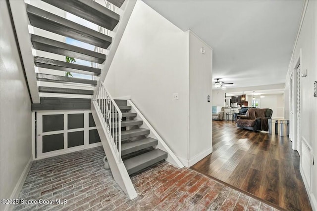 stairway featuring ceiling fan