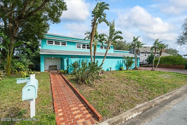 view of front of home featuring a garage and a front lawn