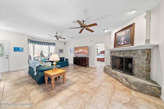 living room featuring ceiling fan and a fireplace