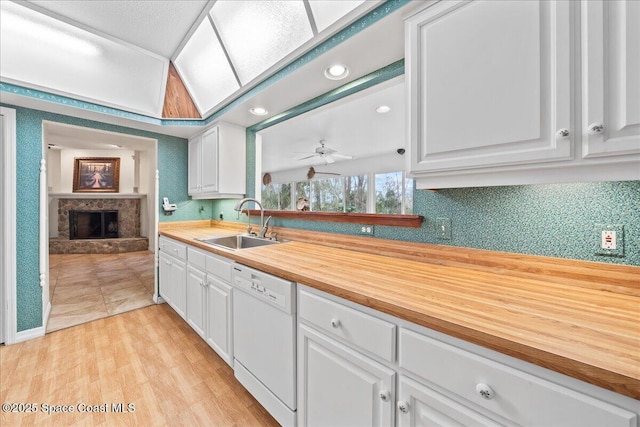 kitchen with white cabinetry, sink, white dishwasher, and butcher block counters