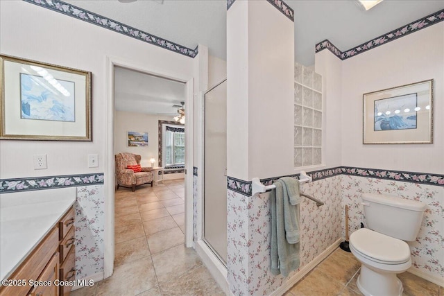 bathroom featuring tile patterned floors, vanity, toilet, and a shower with door