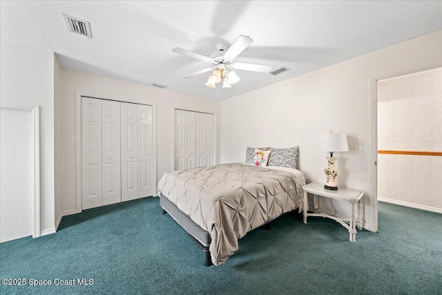 bedroom with two closets, carpet floors, and ceiling fan