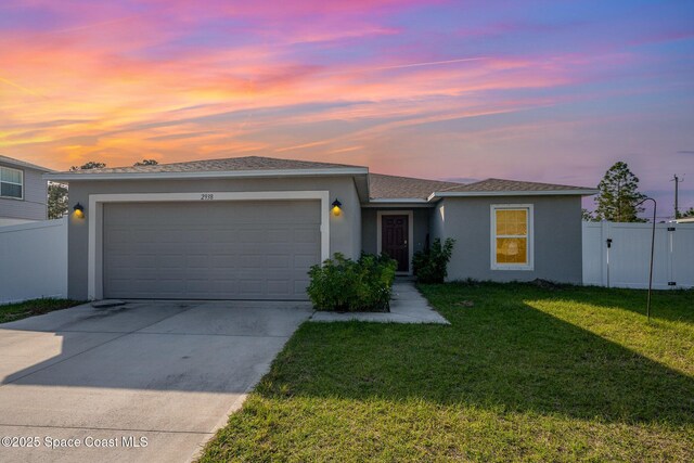 ranch-style house featuring a garage and a lawn