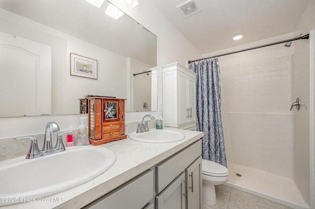 bathroom with a shower with curtain, vanity, toilet, and tile patterned flooring