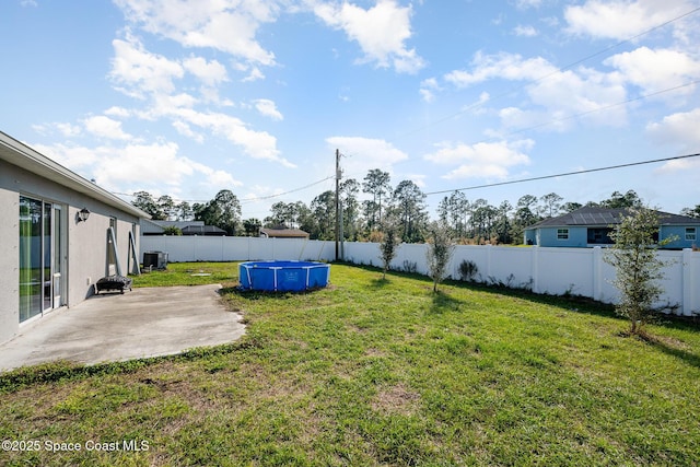 view of yard featuring a fenced in pool, a patio, and central air condition unit