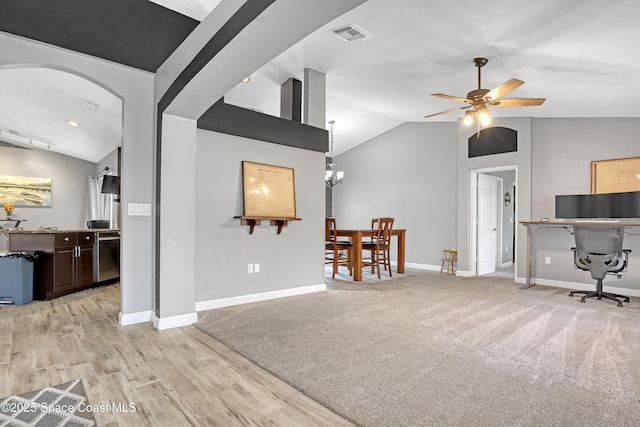 home office featuring lofted ceiling, ceiling fan with notable chandelier, and light wood-type flooring