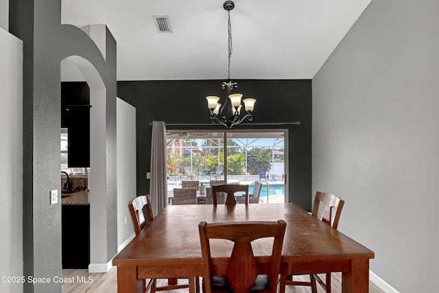 dining room featuring light wood-type flooring and an inviting chandelier