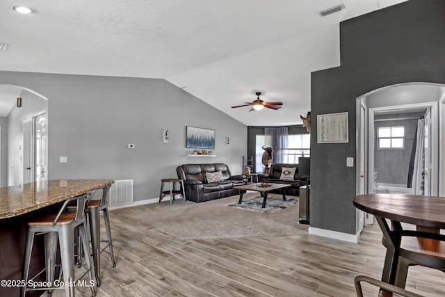 living room with vaulted ceiling, ceiling fan, and light hardwood / wood-style flooring