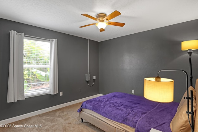 bedroom featuring a textured ceiling, ceiling fan, and carpet