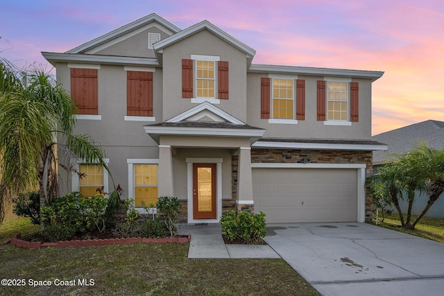 1545 Litchfield Dr, Melbourne, FL 32904 - view of front of home with stucco siding, an attached garage, concrete driveway, and stone siding