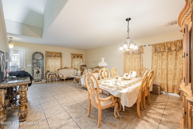 tiled dining space featuring a notable chandelier