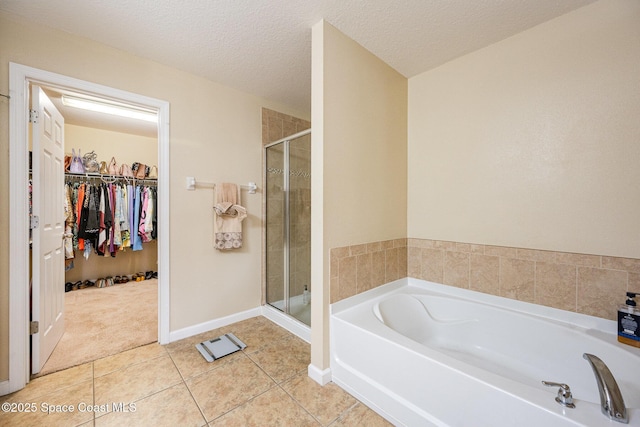 bathroom with tile patterned flooring, separate shower and tub, and a textured ceiling