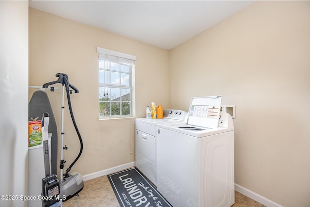 clothes washing area featuring light tile patterned flooring and separate washer and dryer