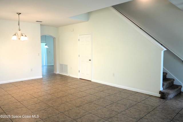 1545 Litchfield Dr, Melbourne, FL 32904 - unfurnished living room featuring arched walkways, stairway, a chandelier, tile patterned floors, and baseboards
