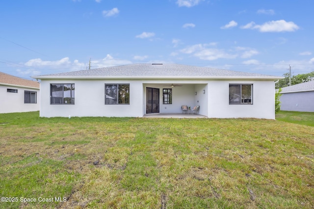 back of property with a yard and a patio