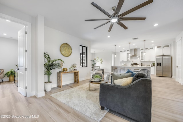 living room with light hardwood / wood-style flooring and ceiling fan