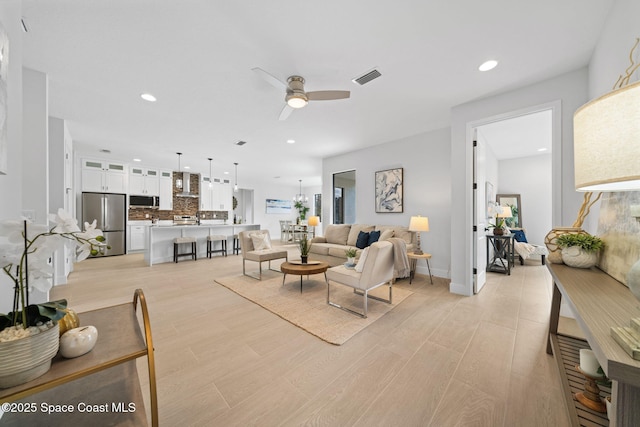 living room featuring ceiling fan and light hardwood / wood-style floors