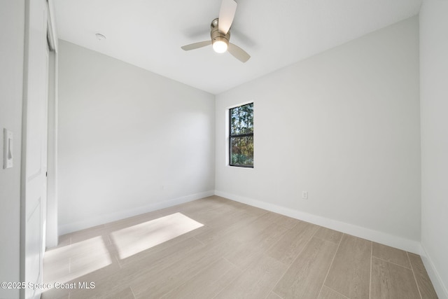 spare room with ceiling fan and light wood-type flooring