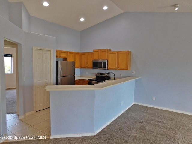 kitchen featuring light colored carpet, a peninsula, stainless steel appliances, light countertops, and high vaulted ceiling