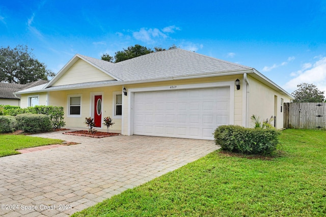 ranch-style house featuring a garage and a front yard