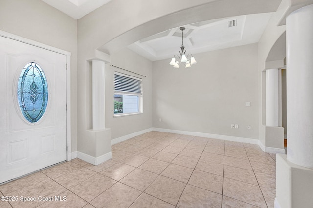 foyer entrance with coffered ceiling, light tile patterned floors, and a notable chandelier