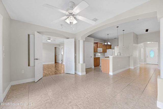 unfurnished living room with sink, ceiling fan, and light tile patterned flooring