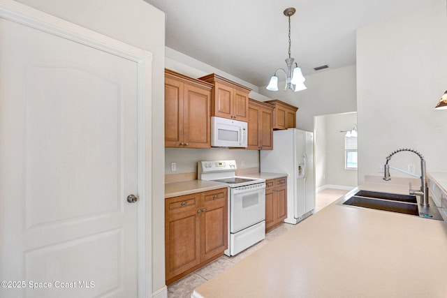 kitchen with light tile patterned flooring, sink, an inviting chandelier, decorative light fixtures, and white appliances