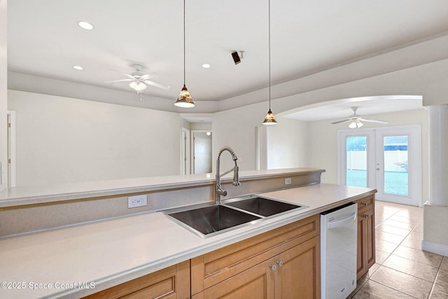 kitchen with pendant lighting, dishwasher, sink, light tile patterned floors, and french doors