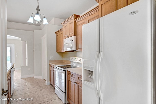 kitchen with an inviting chandelier, pendant lighting, white appliances, and light tile patterned floors