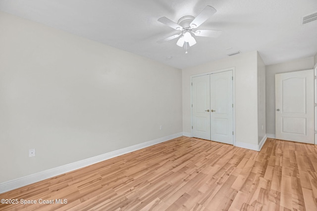 unfurnished bedroom featuring light hardwood / wood-style flooring, a closet, and ceiling fan