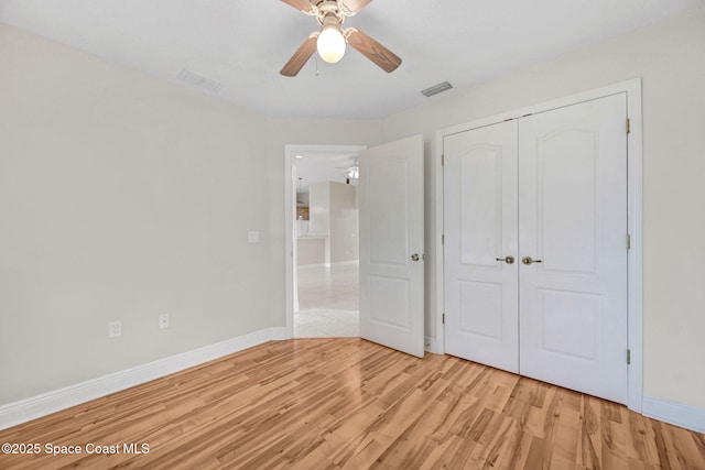 unfurnished bedroom featuring ceiling fan, light hardwood / wood-style floors, and a closet