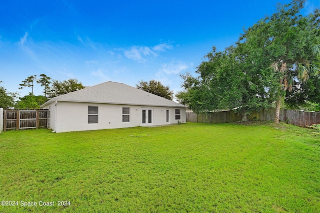 back of house with a lawn