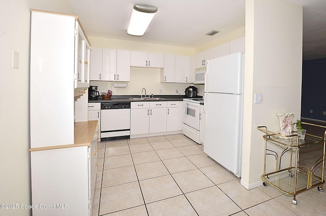 kitchen featuring white cabinetry, white appliances, light tile patterned flooring, and sink