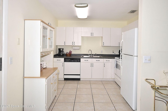 kitchen featuring white cabinetry, sink, white appliances, and light tile patterned floors