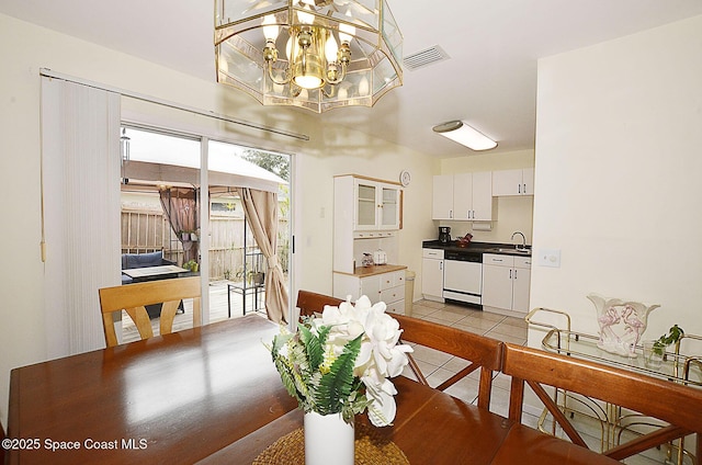 dining room featuring a notable chandelier, sink, and light tile patterned floors