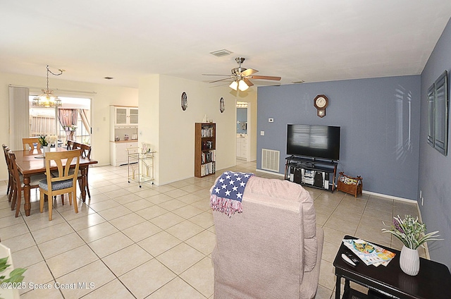 living room featuring light tile patterned flooring and ceiling fan with notable chandelier