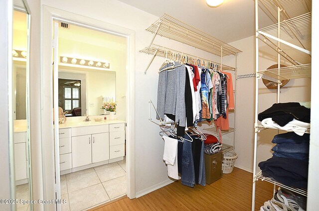 spacious closet featuring sink and light hardwood / wood-style flooring