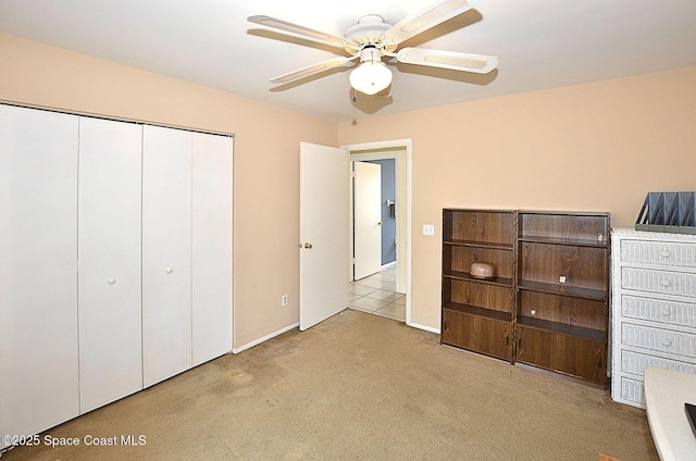 unfurnished bedroom with ceiling fan, light colored carpet, and a closet