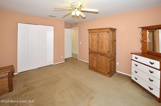 unfurnished bedroom with light carpet, ceiling fan, and a closet