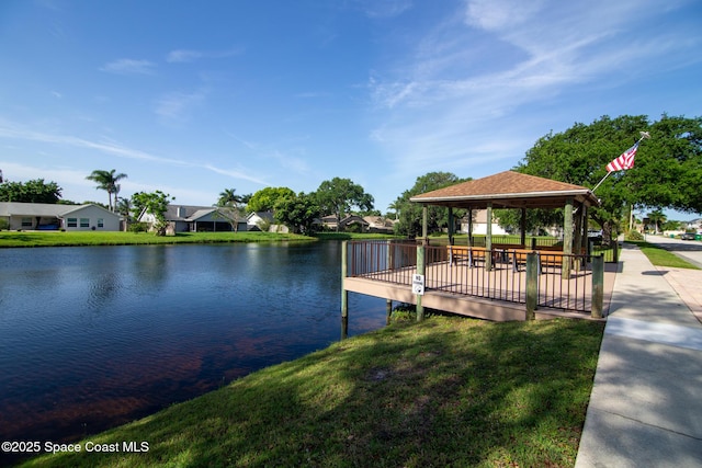 view of dock featuring a gazebo, a water view, and a yard