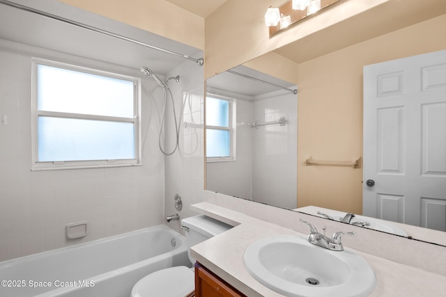 full bathroom featuring tiled shower / bath combo, vanity, and toilet