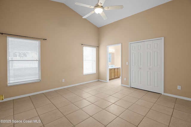 unfurnished bedroom with high vaulted ceiling, a closet, ceiling fan, and light tile patterned flooring