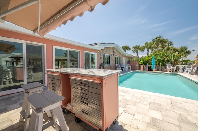 view of pool with exterior bar and a patio