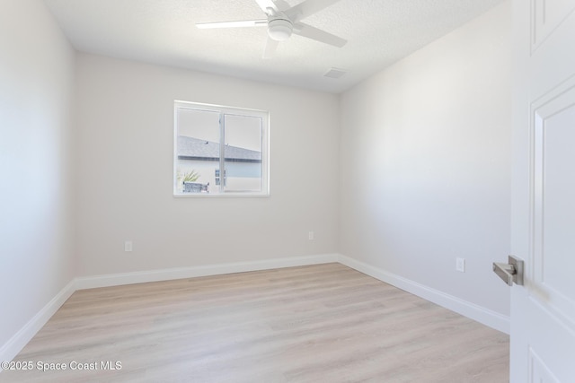 empty room featuring a textured ceiling, light hardwood / wood-style flooring, and ceiling fan