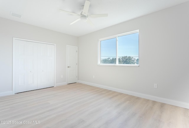 unfurnished bedroom featuring light hardwood / wood-style floors, a closet, and ceiling fan