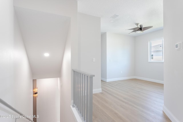 corridor featuring light hardwood / wood-style floors and a textured ceiling