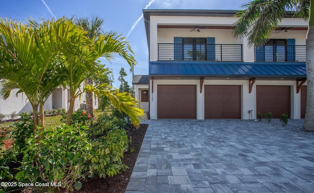 view of front of home with ceiling fan, a balcony, and a garage