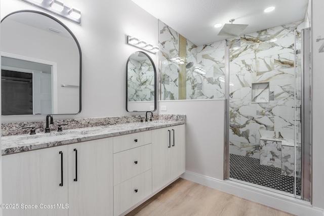 bathroom featuring vanity, hardwood / wood-style floors, and a tile shower