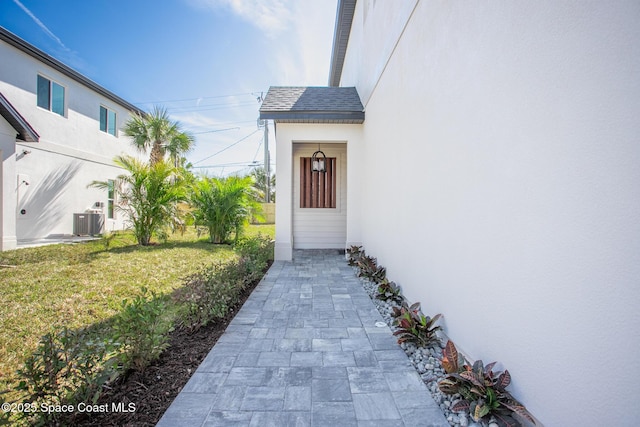 view of exterior entry with cooling unit and a yard