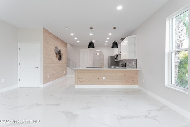 kitchen featuring a wealth of natural light, decorative light fixtures, white cabinets, kitchen peninsula, and stainless steel appliances